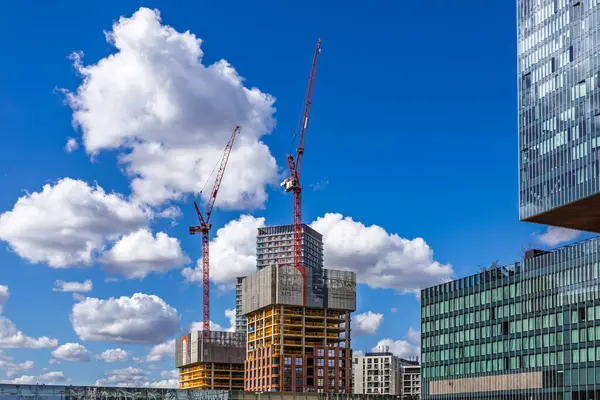 Gökdelen inşaatını vinçle ve kısmen gündüz inşa edilmiş yapıları gösteren kentsel gelişim sahnesi. Londra, İngiltere, 30 Mart 2024