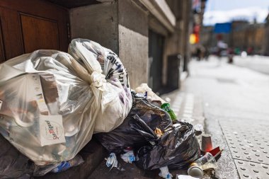Şehir duvarının yanındaki kaldırıma yığılmış çöp torbaları, kentsel atık ve temizlik sorunlarını vurguluyor. Londra, İngiltere, 30 Mart 2024