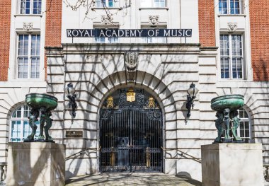 Kraliyet Müzik Akademisi 'nin tarihi girişinde süslü demir kapılar ve klasik taş mimari sergileniyor. Londra, İngiltere, 1 Nisan 2024
