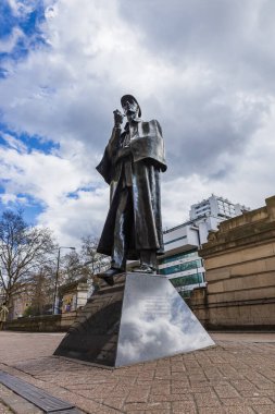 Sherlock Holmes 'un Londra' daki bronz heykeli. Detaylı özellikleri var. Bulutlu gökyüzüne karşı dik duruyor. Londra, İngiltere, 1 Nisan 2024