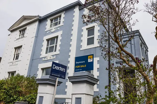 Viktorya döneminden kalma bir teras ve banliyöde görünür bir emlak tabelası var. Londra, İngiltere, 6 Nisan 2024