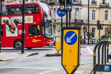 Londra caddesindeki metro istasyonu için yol işareti. Yakınlarda klasik kırmızı otobüs var. Londra, İngiltere, 6 Nisan 2024