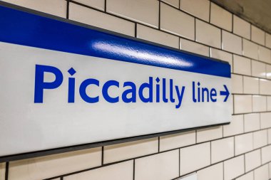 Londra Yeraltı Piccadilly Hattı tabelası bir metro istasyonunun duvarında sergileniyordu..
