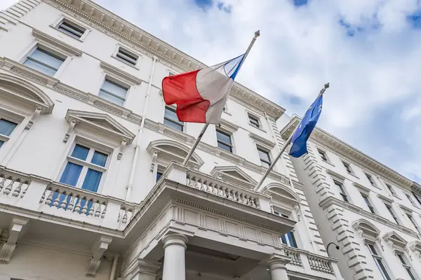 Fransız ve AB bayraklarıyla Londra 'daki Fransız Konsolosluğu klasik beyaz bir yüzün üzerinde dalgalanıyor. Londra, İngiltere, 7 Nisan 2024
