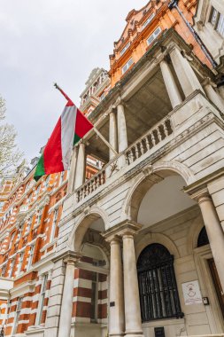 Londra 'daki Umman Sultanlığı' nın elçiliğinin düşük açılı görüntüsü. Tarihi kırmızı tuğla ve taş diplomatik binanın balkonundan gelen Umman bayrağı. Londra, İngiltere, 7 Nisan 2024