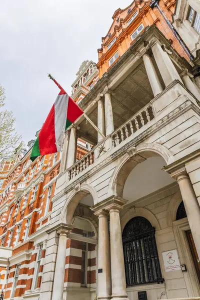 Londra 'daki Umman Sultanlığı' nın elçiliğinin düşük açılı görüntüsü. Tarihi kırmızı tuğla ve taş diplomatik binanın balkonundan gelen Umman bayrağı. Londra, İngiltere, 7 Nisan 2024