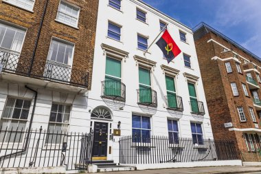 Londra 'daki Angola Büyükelçiliği, ulusal bayrak ve klasik mimari detaylarla dolu beyaz cephe. Londra, İngiltere, 14 Nisan 2024