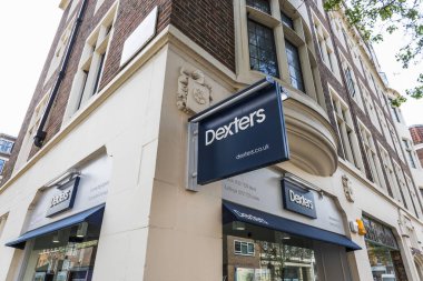 Dexters gayrimenkul bürosunun dışında cesur bir tabela ve şık bir şehir vitrini var. Londra, İngiltere, 14 Nisan 2024