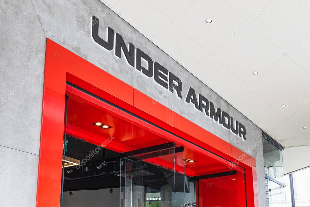 Exterior of Under Armour retail store featuring bold red entry and brand signage. London, UK, 14 April 2024