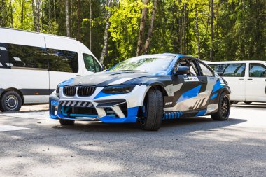 Ağır modifiye edilmiş mavi siyah ambalajlı BMW drift araba, geniş gövdeli çamurluklar ve çayırlarda uçan hava aracı. Alytus, Litvanya, 25 Mayıs 2025