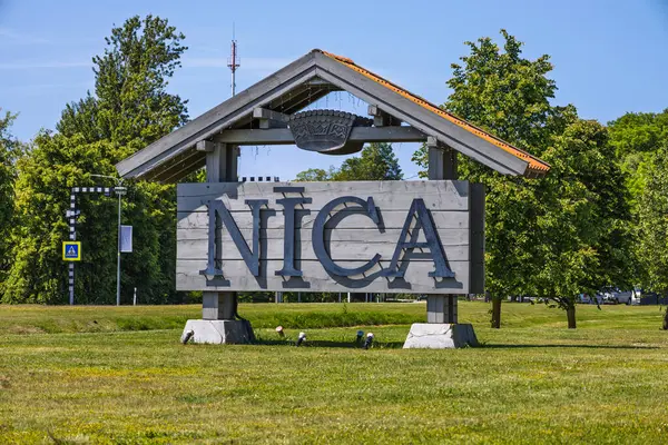 Nica 'nın Letonya kıyı köyünün girişini işaret eden büyük ahşap pavyon tabelası. Nica, Letonya, 17 Haziran 2025