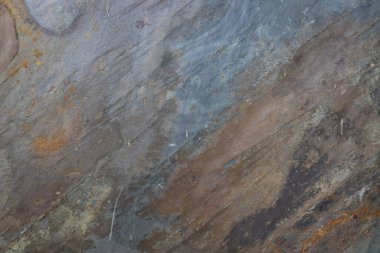 Renkli mineral damarları olan yıpranmış bir metamorfik taş yüzeyini kapatın..