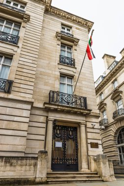 Westminster, Londra 'daki zarif diplomatik görev cephesi. Tahta kapı, Myanmar bayrağı ve taş sütunlar uluslararası ilişkiler, politika ve hükümet temalarını iletiyor. Londra, İngiltere, 14 Nisan 2024