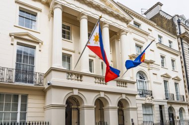 Londra, İngiltere 'deki Filipinler Büyükelçiliği. Sütunlu Neoklasik krema cephesi, Filipin bayrağı ve ASEAN bayrağı dalgalanıyor. Londra, İngiltere, 14 Nisan 2024