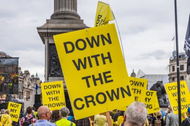 Londra 'nın Trafalgar Meydanı' ndaki yoğun monarşi karşıtı protestolarda, modern İngiliz cumhuriyetçi muhalefetini gösteren CroWN pankartı havada tutularak koyu sarı renge yakın durun. Londra, İngiltere, 5 Mayıs 2024