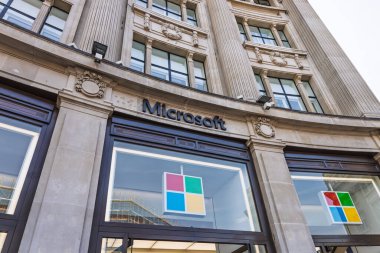 Microsoft 'un tarihi şehir caddesindeki perakende mağazasının girişinde cam ön cephesinde renkli dört kare logo var. Londra, İngiltere, 11 Mayıs 2024