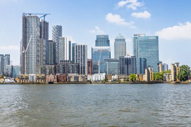Canary Wharf gökdelenleriyle gösterişli Londra kıyı şeridi Thames Nehri 'ne yansıyarak küresel finans ve modern mimariyi sembolize etti. Londra, İngiltere, 19 Mayıs 2024