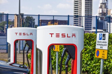 Şehir parkındaki ikiz Tesla Supercharger 'ları kapatın. Elektrikli arabalar için hızlı ve çevre dostu güç sağlayın. Londra, İngiltere, 19 Mayıs 2024