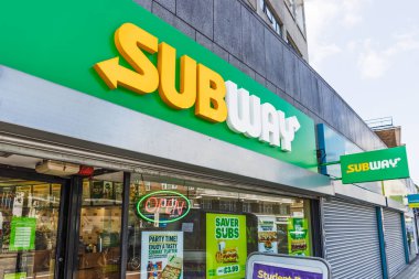 Dışı yeşil sarı tabelası, cam girişi ve tanıtım posterleri olan metro sandviç dükkanı. Londra, İngiltere, 2 Haziran 2024