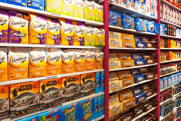 Bir mağaza koridorunda düzgünce istiflenmiş renkli ambalajlı abur cuburların yakın görüntüsü, ABD 'de şeker çeşitliliği ve ürün yerleştirme sergileniyor. Londra, İngiltere, 2 Haziran 2024
