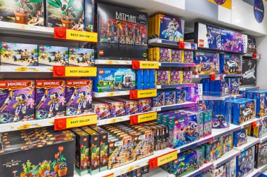 Canlı oyuncak mağazası koridoru çeşitli LEGO bina setleri, fiyat etiketleri ve parlak raflarla dolu. Londra, İngiltere, 2 Haziran 2024