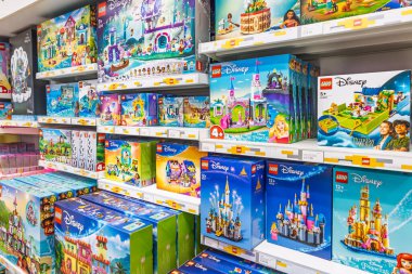 Düzinelerce LEGO seti temiz beyaz raflardaki temalara göre sıralanır. Renkli ambalajlar tatil hediyesi alışverişini ve perakende satışını gösteriyor. Londra, İngiltere, 2 Haziran 2024