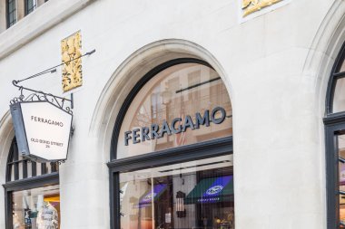 Ferragamo butik mağazası kemerli taş cepheli, cam camlı pencereli ve şık bir alışveriş caddesinde logo işaretli. Londra, İngiltere, 8 Haziran 2024