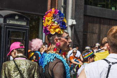 Londra Gururu 2024 'ün kostümlü katılımcısı, canlı çiçek başlığı. Şenlikli şehir kalabalığı, gökkuşağı ayrıntıları, kapsayıcılık ve neşeli sokak geçidi enerjisi. Londra, İngiltere, 29 Haziran 2024