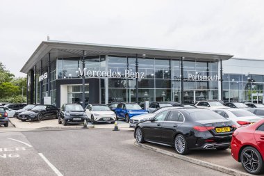 Mercedes Benz 'in Portsmouth, İngiltere' deki dış görünüşü. Cam galerisi, park edilmiş arabalar ve marka tabelaları. Portsmouth, İngiltere, 3 Temmuz 2024
