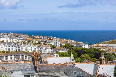 St. Ives, Cornwall 'ın yükseltilmiş manzarası, beyazlatılmış çatıları, kilise kulesi ve Atlantik ötesinde