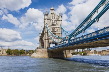 Londra 'da Thames Nehri' ni kapsayan Tower Bridge 'in yakın görüntüsü. Viktorya dönemi Gotik mimarisi, parlak gün ışığı, mavi süspansiyon kabloları, insan yok..
