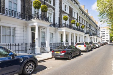 Batı Londra 'daki şık Gürcü - Viktorya dönemi evlerinde siyah korkuluklar, kesilmiş çalı çırpı, park edilmiş arabalar ve huzurlu, lüks bir mahalle havası var. Londra, İngiltere, 24 Mayıs 2023