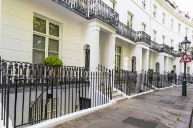 Kavisli bir Londra yerleşim sokağında demiryolu döşeyen beyaz Gürcü evleri..