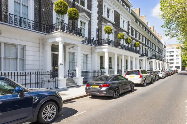 Batı Londra 'daki şık Gürcü - Viktorya dönemi evlerinde siyah korkuluklar, kesilmiş çalı çırpı, park edilmiş arabalar ve huzurlu, lüks bir mahalle havası var. Londra, İngiltere, 24 Mayıs 2023
