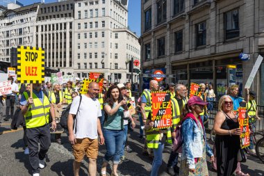 Londra 'nın merkezinde ULEZ dur işaretleriyle kalabalık yürüyüşleri, kalabalık bir caddede halk eylemciliği, sivil protesto ve kentsel politika gerilimlerini vurguluyor. Londra, İngiltere, 27 Mayıs 2023