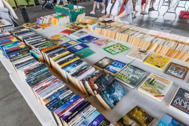 Okuyucular ve koleksiyoncular için bir kamu pazarında düzenlenmiş renkli kitap koleksiyonu. Londra, İngiltere, 24 Haziran 2023