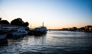 ZADAR, CROATIA - Kasım 02, 2022: Şehrin diğer tarafındaki binalar ve limanla gün batımında manzara.