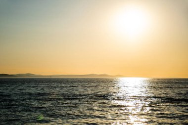 Adriyatik denizi ve Hırvatistan 'ın Zadar kentinde görülen Ugljan adası üzerinde gün batımı.