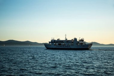 ZADAR, CROATIA - NOVEMBER 01, 2022: Arka planda Ugljan Adası ile Adriyatik deniz sularında Jadrolinija feribot
