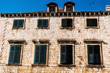 Yeşil pencereli ve çatısı bacalı bir kaldırım taşı bina. Dubrovnik, Hırvatistan