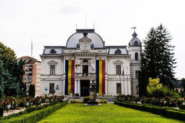 TARGOVISTE, ROMANIA - JULY 28, 2022: Targoviste city hall and the statue of Ion Heliade Radulescu.