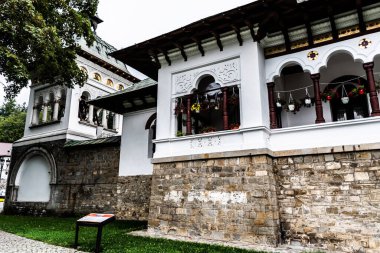 SINAIA, ROMANIA - SEPTEMBER 02, 2022: Sinaia Manastırı 'nın dışı, keşiş evleri ve Nifon Caddesi' ndeki çan kulesi.