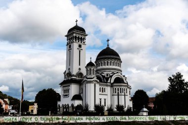 SIGHISOARA, ROMANIA - 22 Eylül 2022: Kutsal Üçleme Kilisesi, Tarnava Mare Nehri 'nin kuzey kıyısında yer alan Rumen Ortodoks Kilisesi.