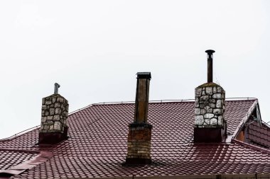 Kahverengi teneke çatı ve 3 tuğla baca..