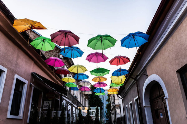 BISTRITA, ROMANIA - JUNE 26, 2023: Pedestrian street with colored umbrellas in the center of Bistrita.