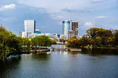 BUCHAREST, ROMANIA - Nisan 09, 2023: Bordei parkındaki Floreasca Gölü 'ndeki Pontoon ve Aurel Vlaicu bölgesindeki ofis binaları.