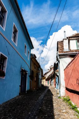 SIGHISOARA, ROMANIA - 23 Eylül 2022: Renkli evleri olan eski ortaçağ caddesi.