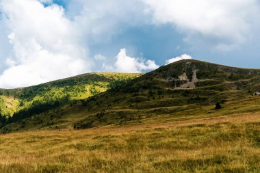 Dağlar, yeşil tepeler ve bulutlu gökyüzü, Transalpina yolu, Romanya.