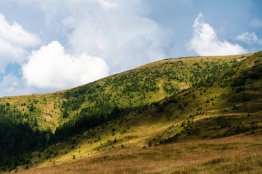 Dağlar, yeşil tepeler ve bulutlu gökyüzü, Transalpina yolu, Romanya.