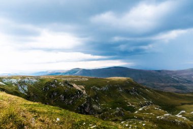 Dağlar, yeşil tepeler ve bulutlu gökyüzü, Transalpina yolu, Romanya.